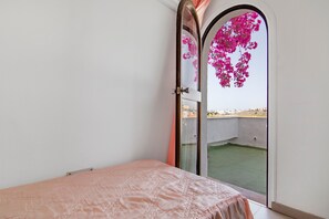 Une chambre à coucher avec un lit, une fenêtre et une vue sur une cour.