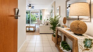 Uma sala de estar moderna com um sofá, mesa de centro e um abajur decorativo.