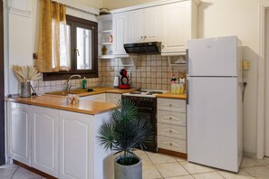 A kitchen with white cabinets, a stove, a sink, and a refrigerator. - Apartment 'Breathing' with Mountain View, Wi-Fi, and Air Conditioning (Virós)
