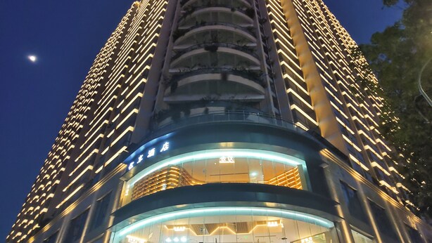 A high-rise hotel with a modern design, featuring a prominent curved glass facade and multiple balconies. - Shenzhen Enjoy Hotel (Huizhou)