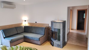 A corner sofa, a small table with a lamp, and a fireplace. - Apartment 'Kastanienhain' with Mountain View, Wi-Fi and Air Conditioning (Laives)