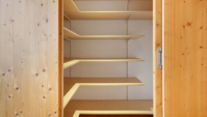 Interior de madera con varias estanterías y una manija de puerta.