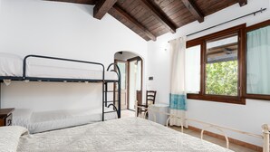 Une chambre avec un lit superposé, un bureau et une fenêtre avec des rideaux.