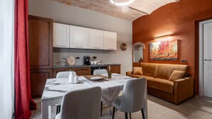 A dining area with a table, chairs, and a sofa. - Apartment 'Il Rifugio Illuminato - Morellino' with Shared Garden, Wi-Fi and Air Conditioning (Semproniano)
