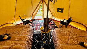 A tent with two beds, a central pole, and a patterned rug. - Hotel O Jerai Nature Glamping (Yan)