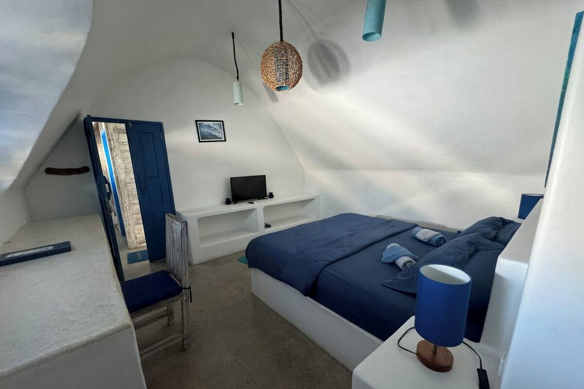 A modern, compact bedroom with a bed, a desk, and a chair.
