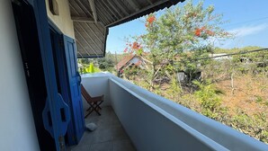 A balcony with a view of a garden and a house. - Bali Bio Villas (Ungasan)