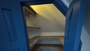 A narrow stairway leading to a room with a sloped ceiling and a small window. - Bali Bio Villas (Ungasan)