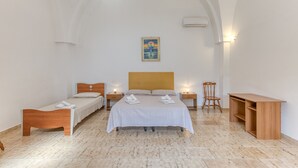 Une chambre d’hôtel avec un grand lit, un lit plus petit, un bureau et une chaise.