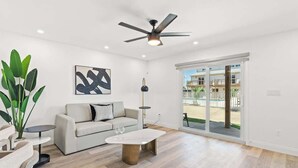 A modern living room with a sofa, coffee table, and a ceiling fan.