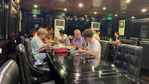 L’intérieur d’un restaurant avec des banquettes en cuir noir, une table noire polie et une enseigne rouge représentant un « festin du dragon ».