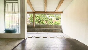 Una habitación con suelo de baldosas, un banco de hormigón y vistas a zonas verdes.