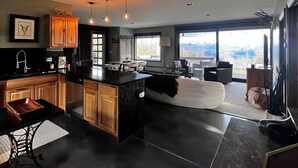 Una cucina moderna con una grande isola, mobili in legno e illuminazione a sospensione.