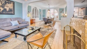 A living room with a sofa, chairs, a coffee table, and a fireplace. - Villa L'Envie d'Eymet – Eco-efficient haven, cool in summer, cozy in winter (Eymet)