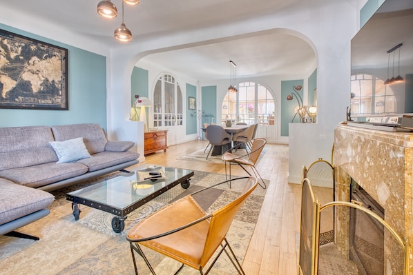 Un salon comprenant un canapé, des fauteuils, une table basse et une cheminée.