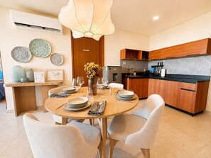 A modern kitchen with wooden cabinets, a black countertop, and a built-in oven. - Condo in Cancun with a pool, gym, and coworking space | Pets allowed, near ZH (Cancún)
