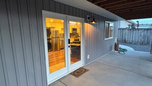 Un immeuble résidentiel doté d’un patio couvert, d’une porte-fenêtre coulissante donnant sur la cuisine et d’une clôture en bois à l’arrière.