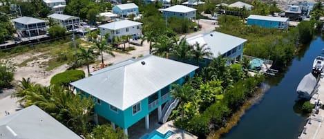 A coastal residential area with houses, a swimming pool, and a marina.