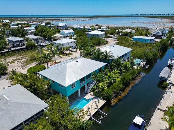 A coastal residential area with houses, a swimming pool, and a marina.