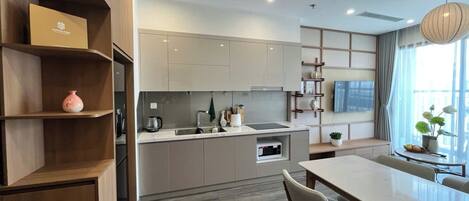 A modern kitchen with a dining area, built-in shelves, and a large window.