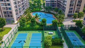 A residential complex with multiple apartment buildings, a central swimming pool, and tennis courts. - Vinhomes Ocean Park- Luxury Apartments (Hanoi)