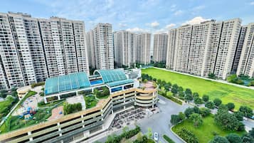 A high-rise residential building complex with multiple apartment buildings, a central courtyard with a swimming pool, and a parking structure.