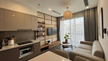Una sala de estar moderna con un sofá, una mesa de comedor y una cocina con televisión.