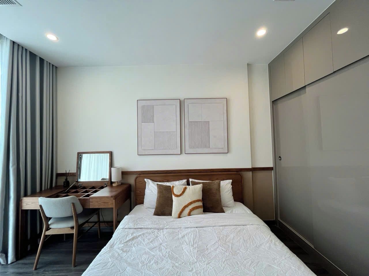 Une chambre d’hôtel avec un lit, un bureau, une chaise et une armoire.
