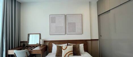 Ein Hotelzimmer mit Bett, Schreibtisch, Stuhl und Kleiderschrank.