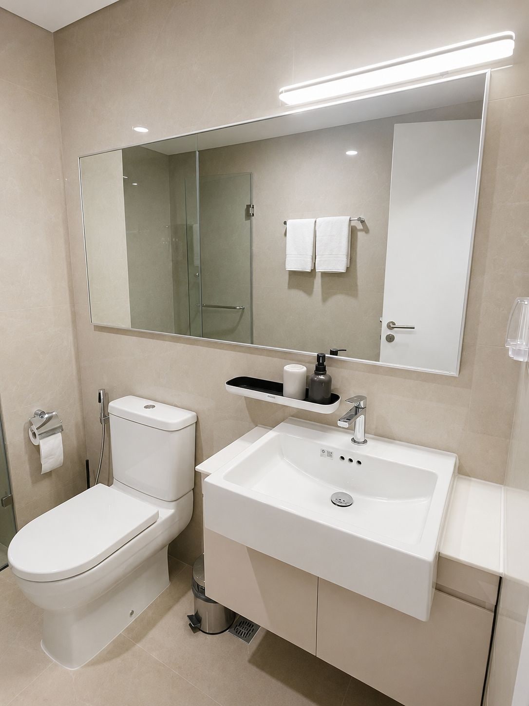 A modern bathroom with a toilet, sink, and shower.