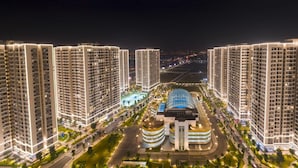 A high-rise residential building complex with multiple apartment towers, a central building with a curved facade, and well-lit streets. - Vinhomes Ocean Park- Luxury Apartments (Hanoi)