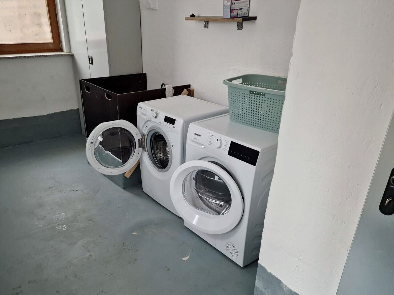 Une buanderie équipée de deux machines à laver à chargement frontal et d’un sèche-linge.
