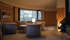 A living room with a fireplace, a sofa, a table, and a lamp.