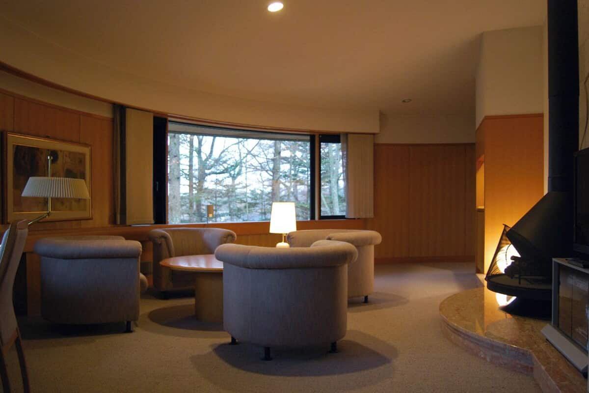 A living room with a fireplace, a sofa, a table, and a lamp.