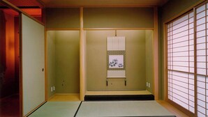 A traditional Japanese room with tatami flooring, sliding doors, and shoji screens.