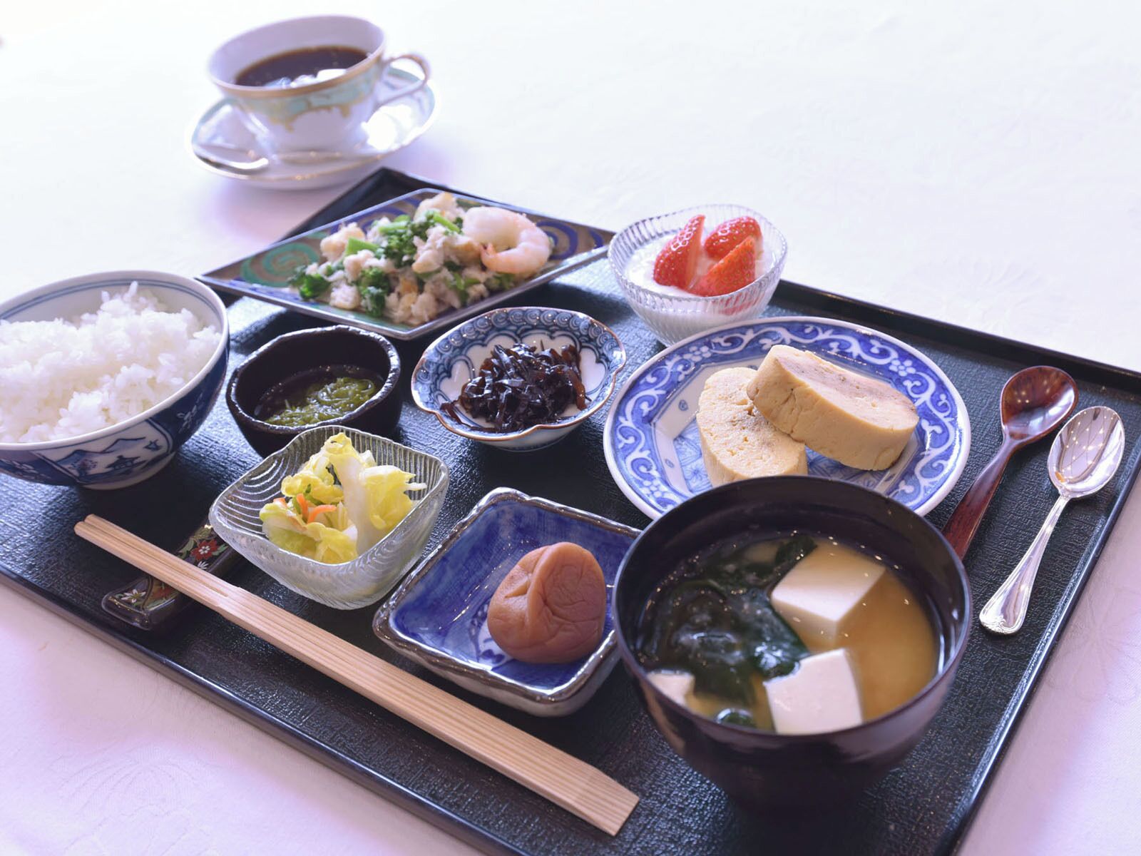 Un repas japonais traditionnel composé de riz, de soupe et de divers accompagnements, le tout servi sur un plateau.