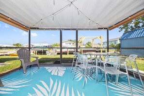A covered patio area with a pool table, chairs, and a table. - Waterfront 2BR Jacuzzi, Private Dock, Gulf Access, Dogs OK, Open for Scalloping! (Hudson)