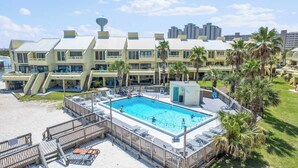 A hotel with a swimming pool, outdoor seating, and palm trees. - Peaceful Paradise - Boat Slip, Pool & Beach Access (Navarre)