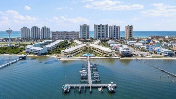 A coastal resort with a marina, high-rise buildings, and a clear view of the ocean. - Peaceful Paradise - Boat Slip, Pool & Beach Access (Navarre)