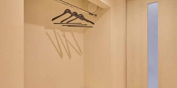 A closet with three black hangers on a rod. - Rakuten STAY Hakone Susuki Grass Fields (Hakone)