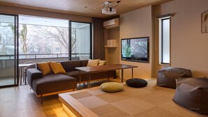 A modern living room with a sofa, a coffee table, and bean bags. - Rakuten STAY Hakone Susuki Grass Fields (Hakone)