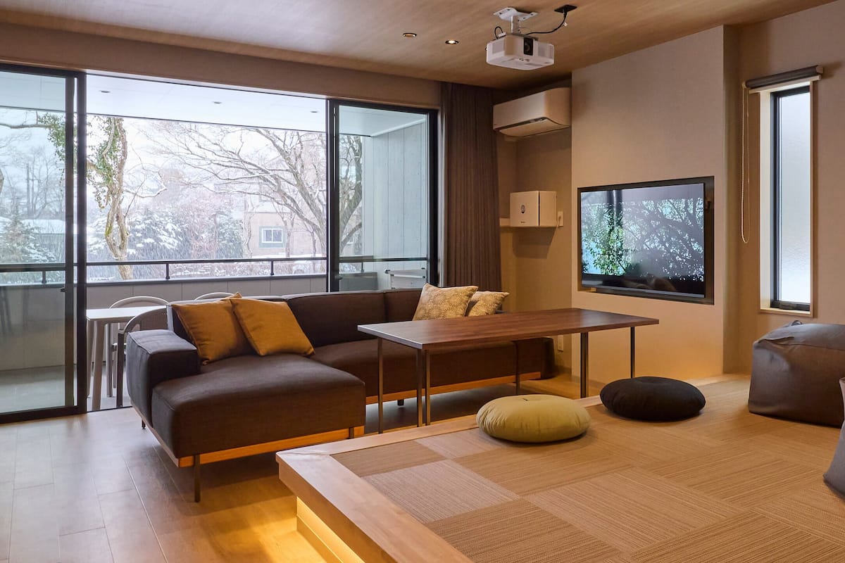 A modern living room with a sofa, a coffee table, and bean bags.