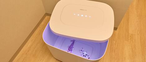 A white Easycare portable toilet with a purple interior, placed on a wooden floor.