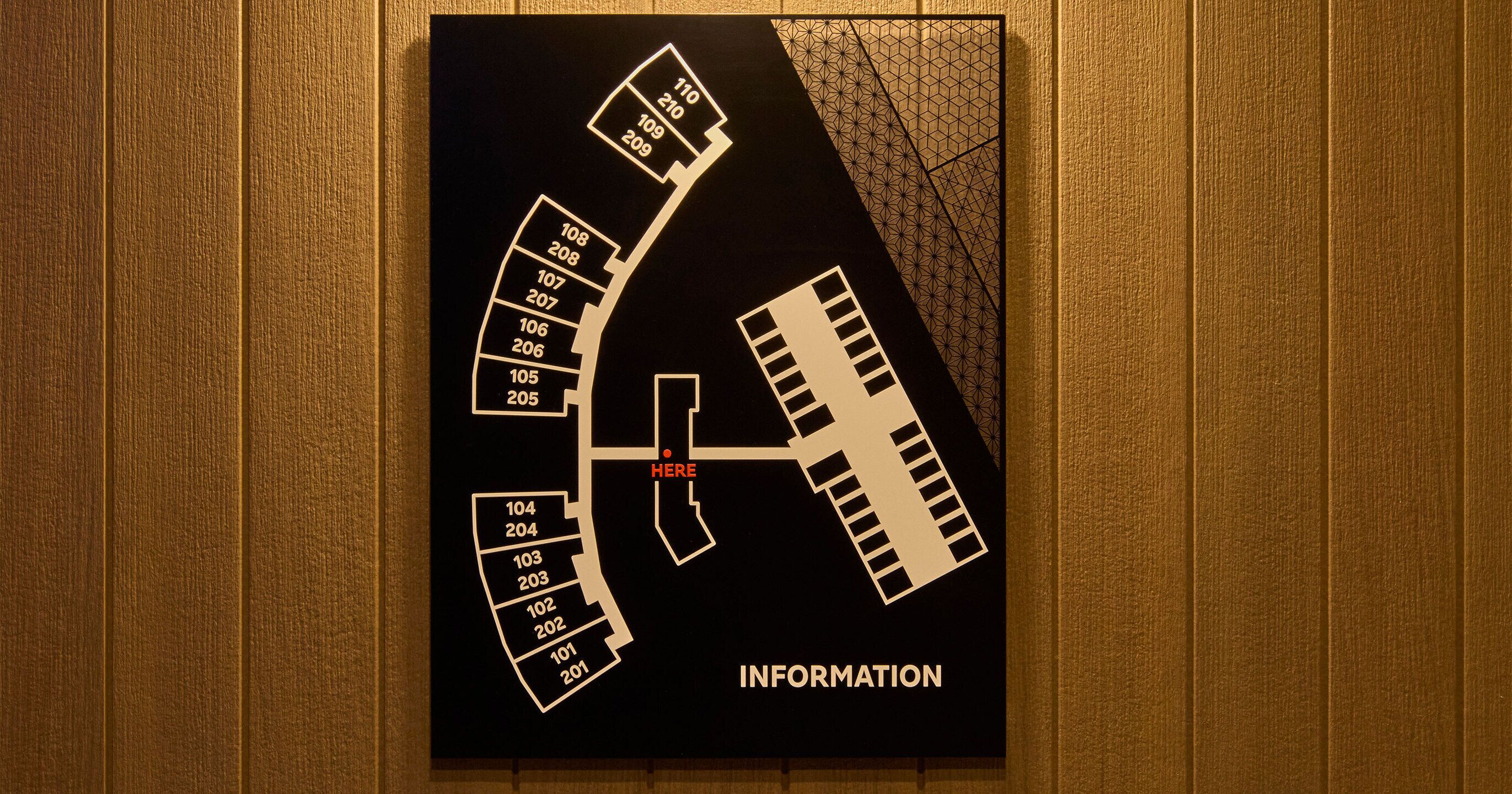 A hotel information board with a floor plan and room numbers.