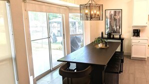 A modern kitchen with a dark countertop, a hanging light fixture, and a view through large sliding glass doors. - Time to Grill with Gas BBQ, Smoker, with Big Yard. Large office and new appliances (Round Rock)
