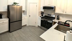 A modern kitchen with a stainless steel refrigerator, a microwave, an oven, and a sink. - Time to Grill with Gas BBQ, Smoker, with Big Yard. Large office and new appliances (Round Rock)