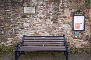 Un mur de pierre avec un banc et une plaque indiquant l’église Sainte-Marie.