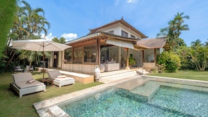 A modern house with a pool, outdoor seating, and tropical landscaping. - Villa Mogi by Villa Finder (Seminyak)