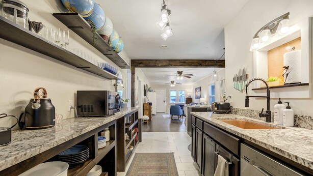 Een moderne keuken met marmeren aanrechtbladen, een inbouwoven en een groot kookeiland met spoelbak.