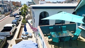 A balcony with outdoor seating, a pool, and a view of the street.